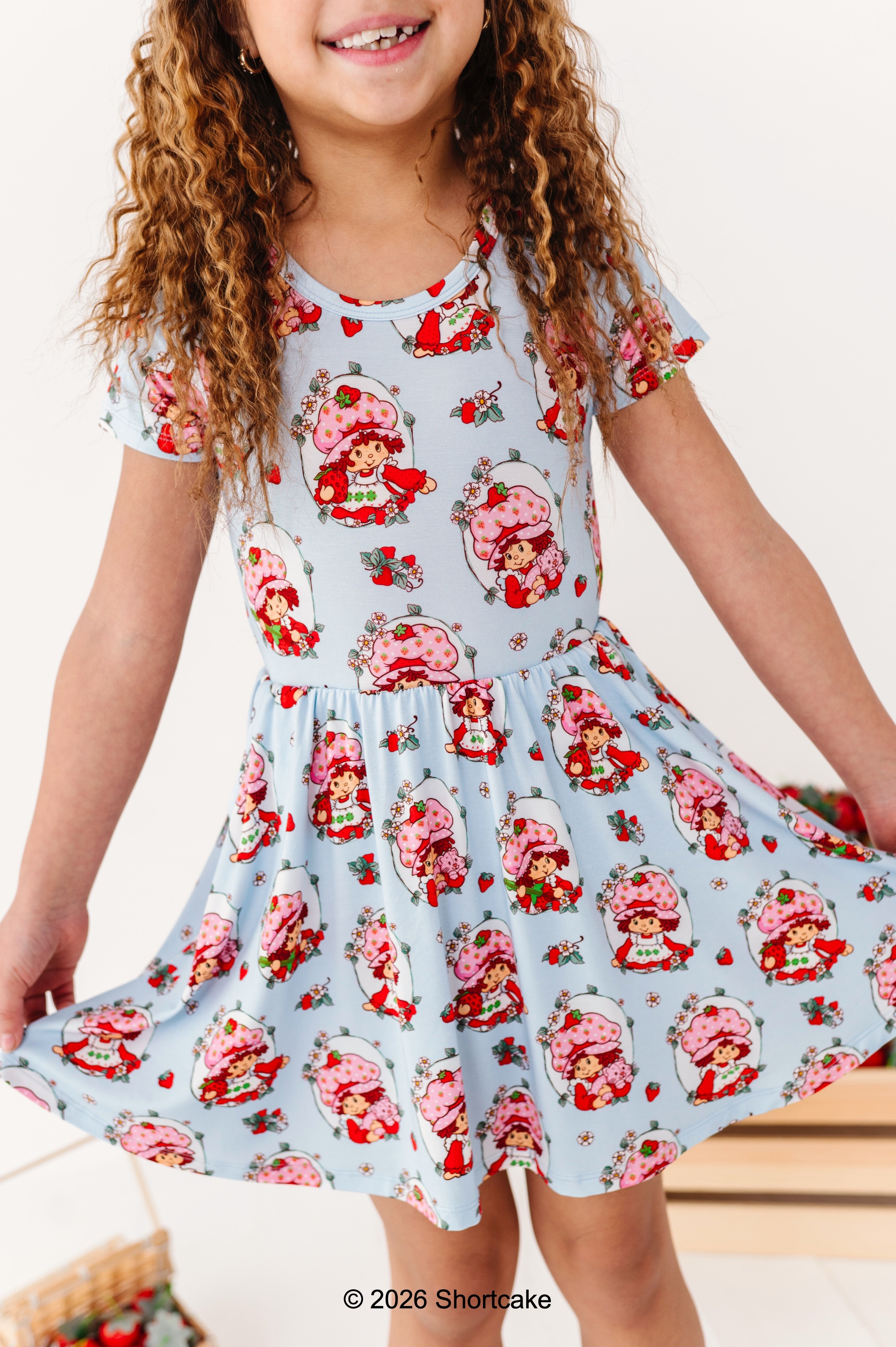 Child wearing a Strawberry Shortcake™ bamboo dress with pockets